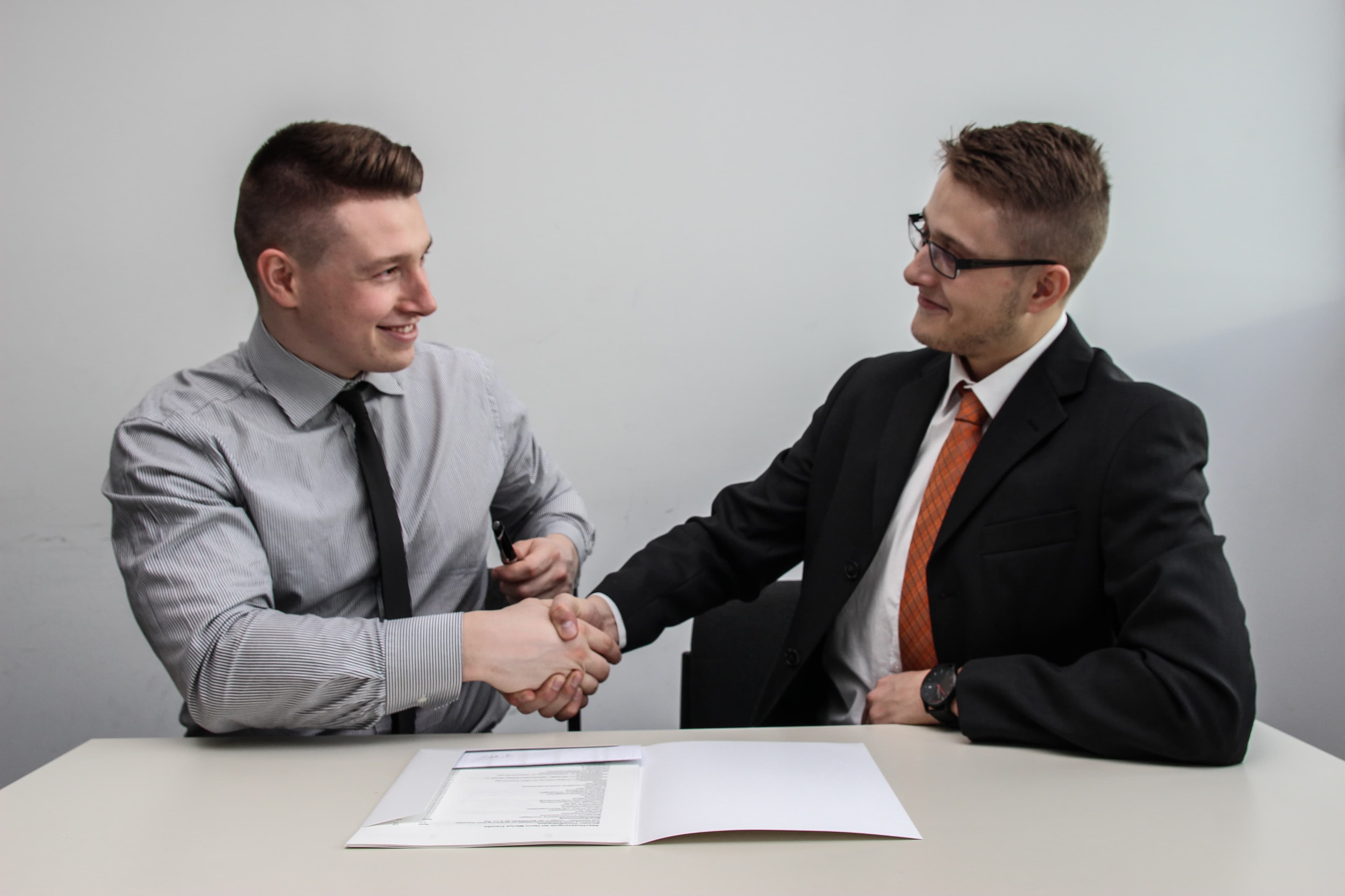 two actuaries shaking hands having agreed a deal